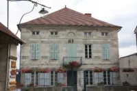 Maison ancienne avec volets bleus et fleurs.