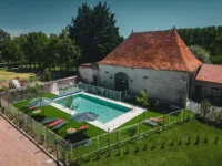 Piscine extérieure près maison en pierres.