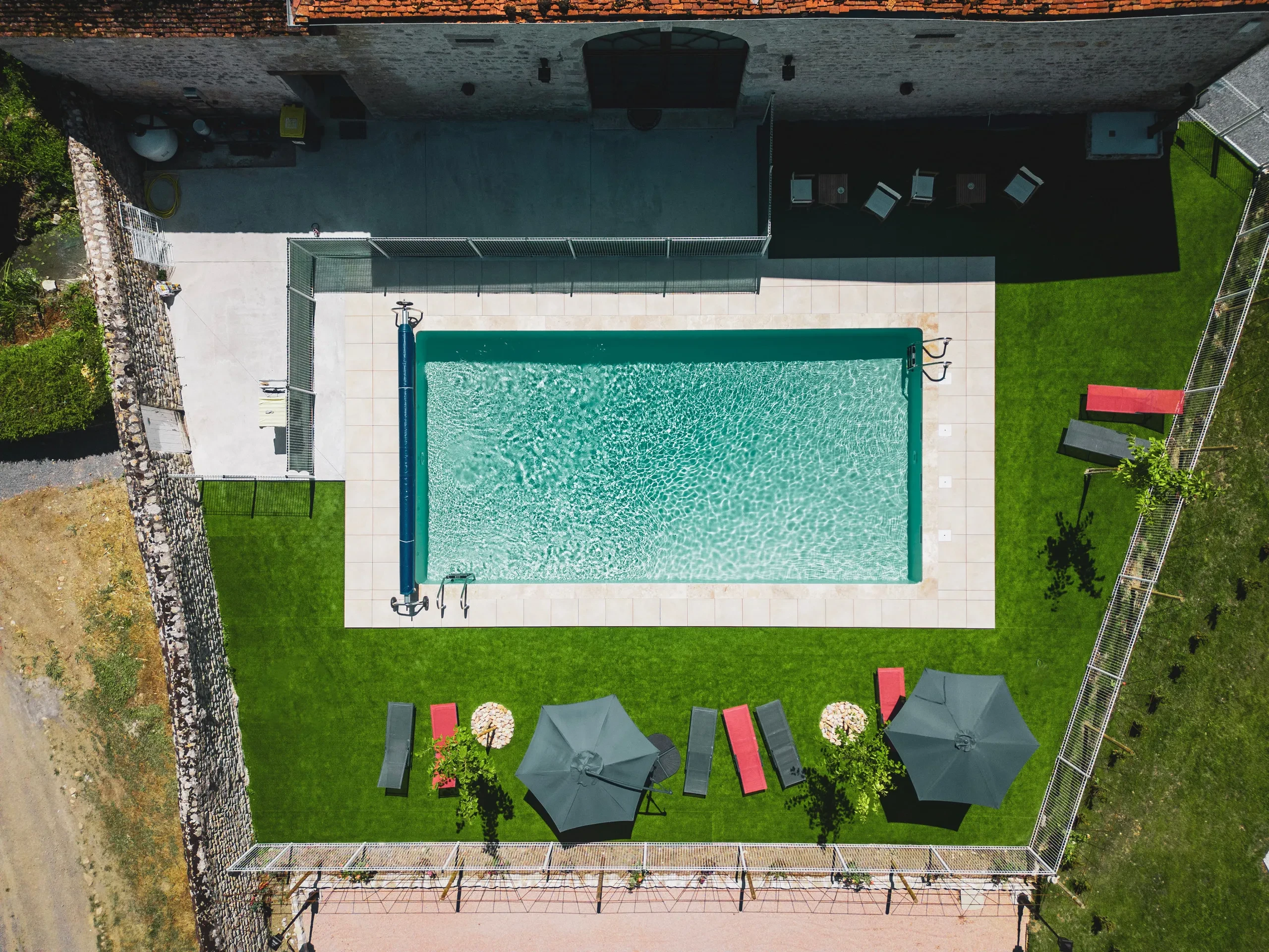 Vue aérienne d'une piscine et jardin.