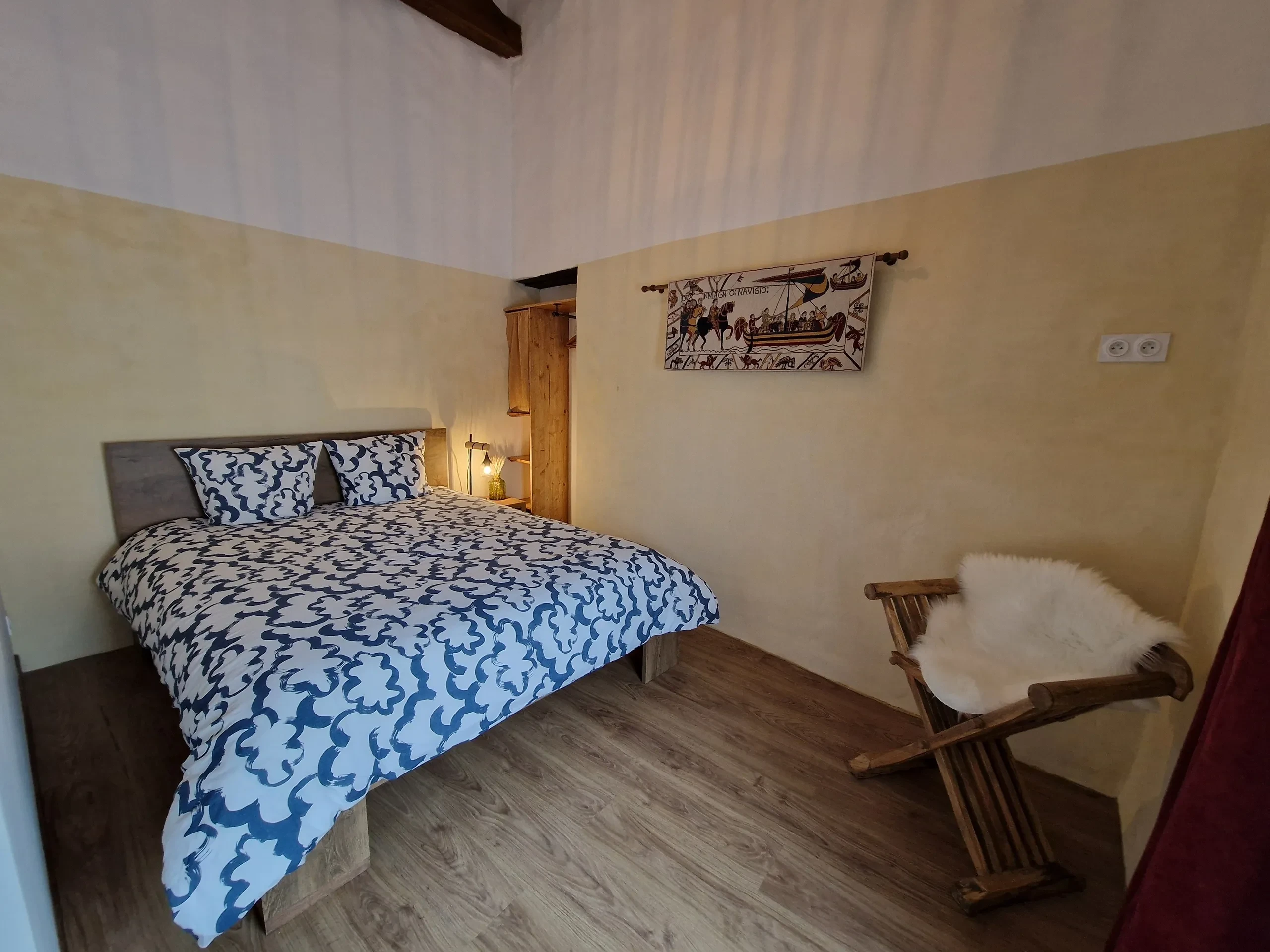 Chambre avec lit double et fauteuil.