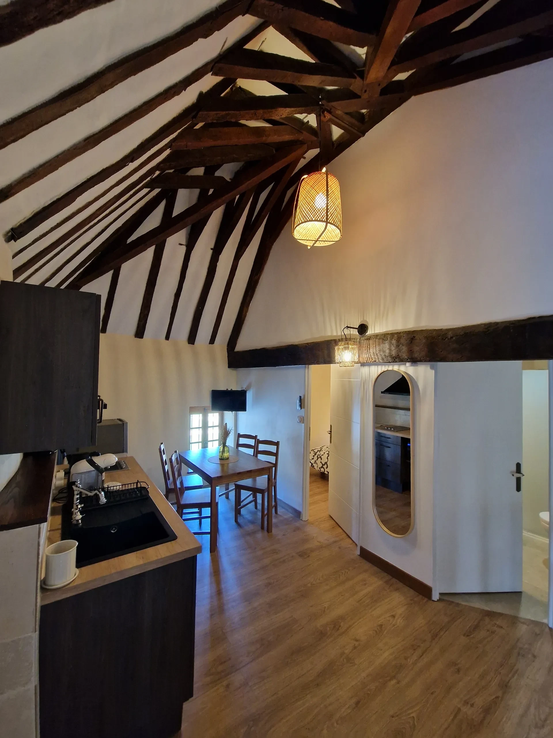Intérieur avec poutres apparentes et table à manger.