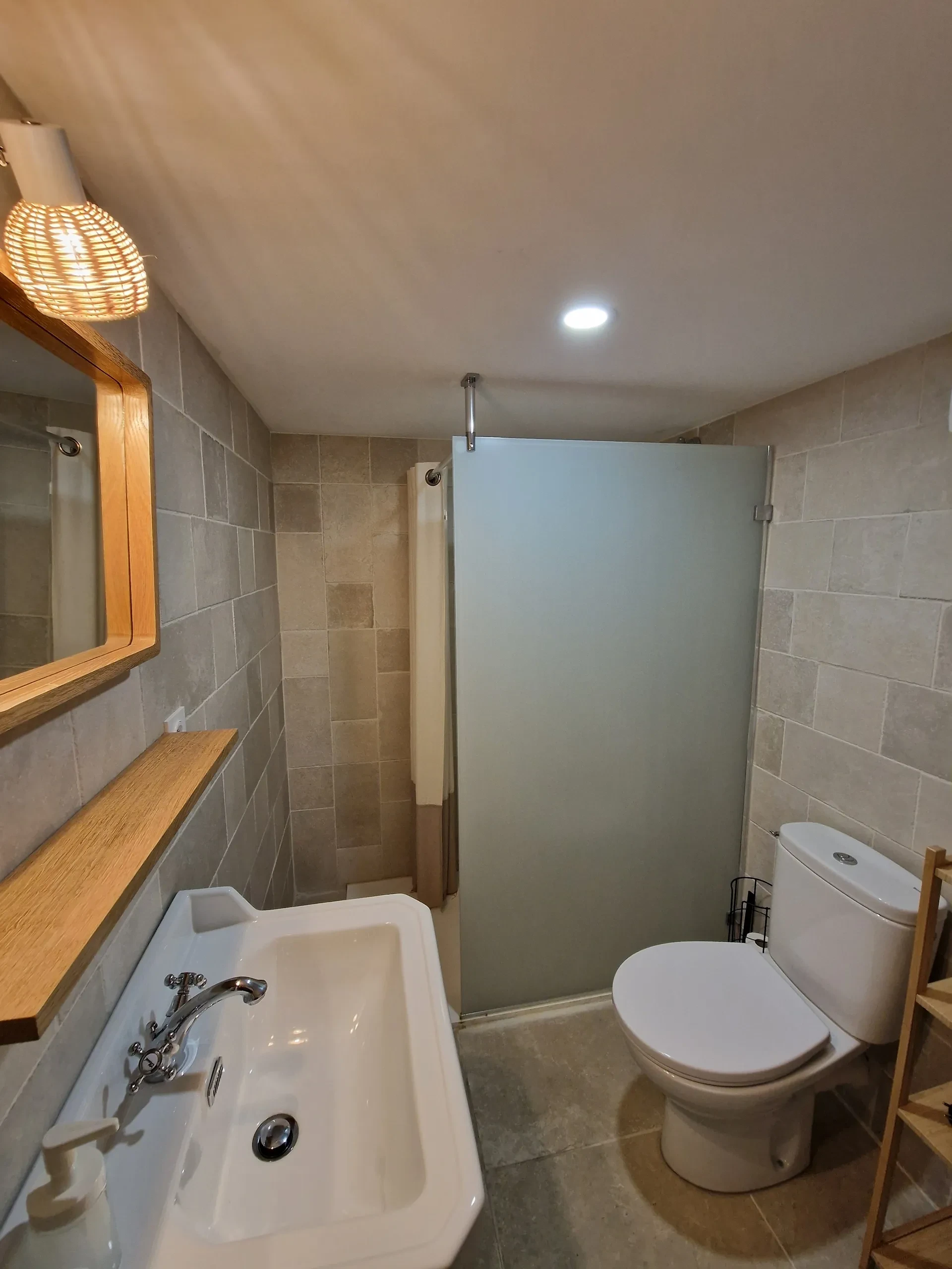 Salle de bain moderne avec douche et lavabo.