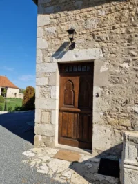 Porte en bois sur mur de pierres anciennes.