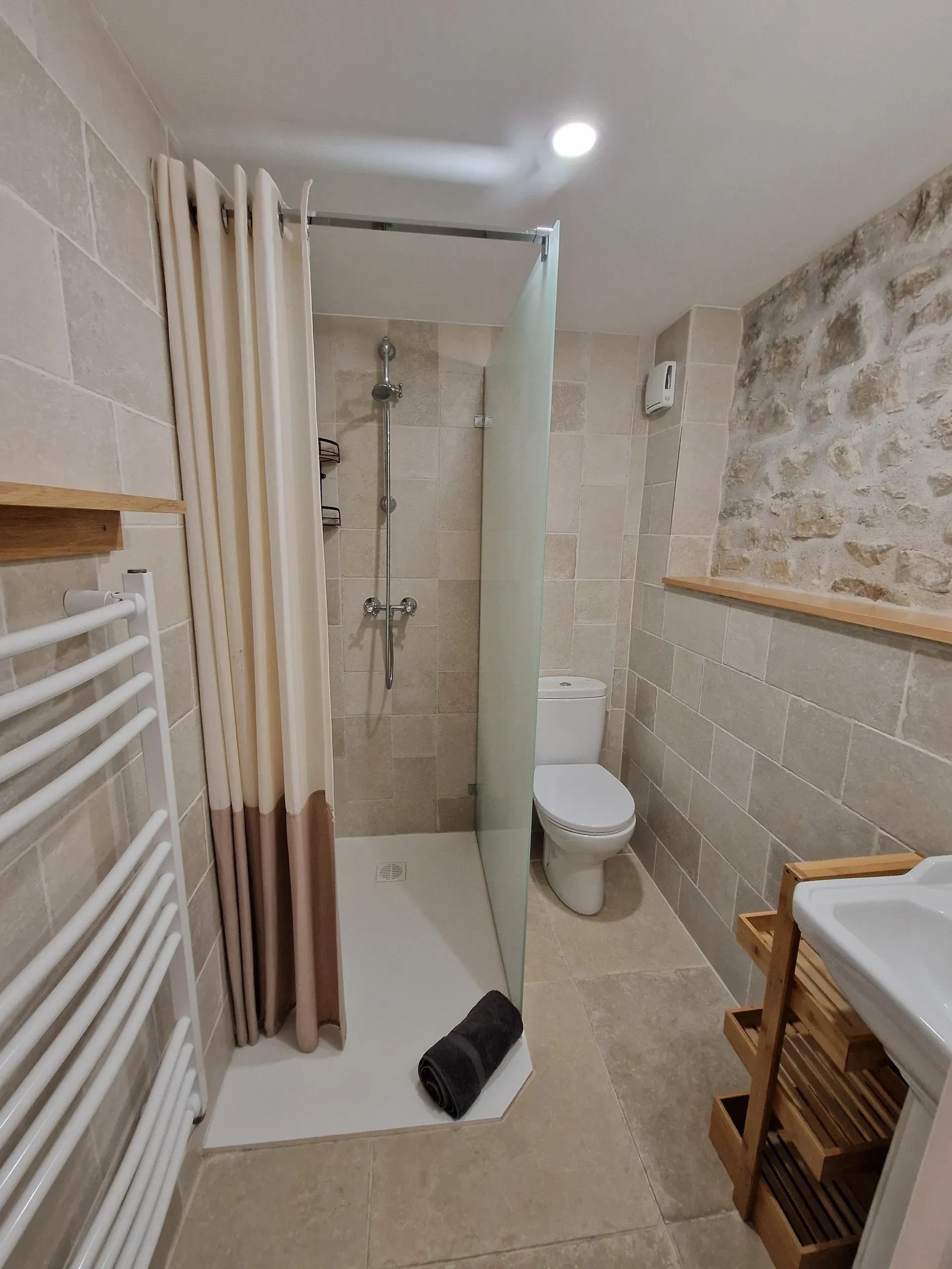 Salle de bain moderne avec douche et toilettes.