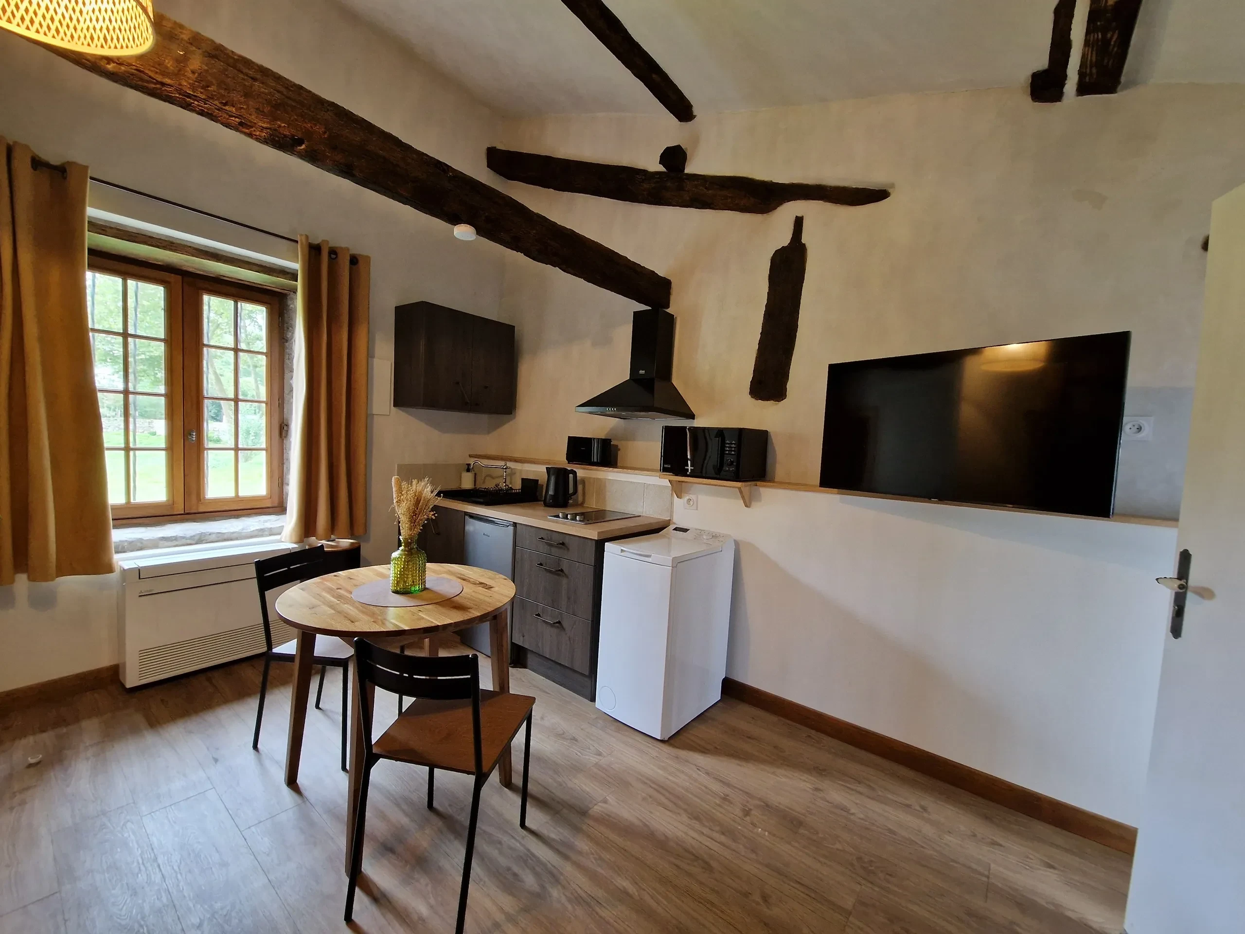 Cuisine de campagne moderne avec poutres apparentes.