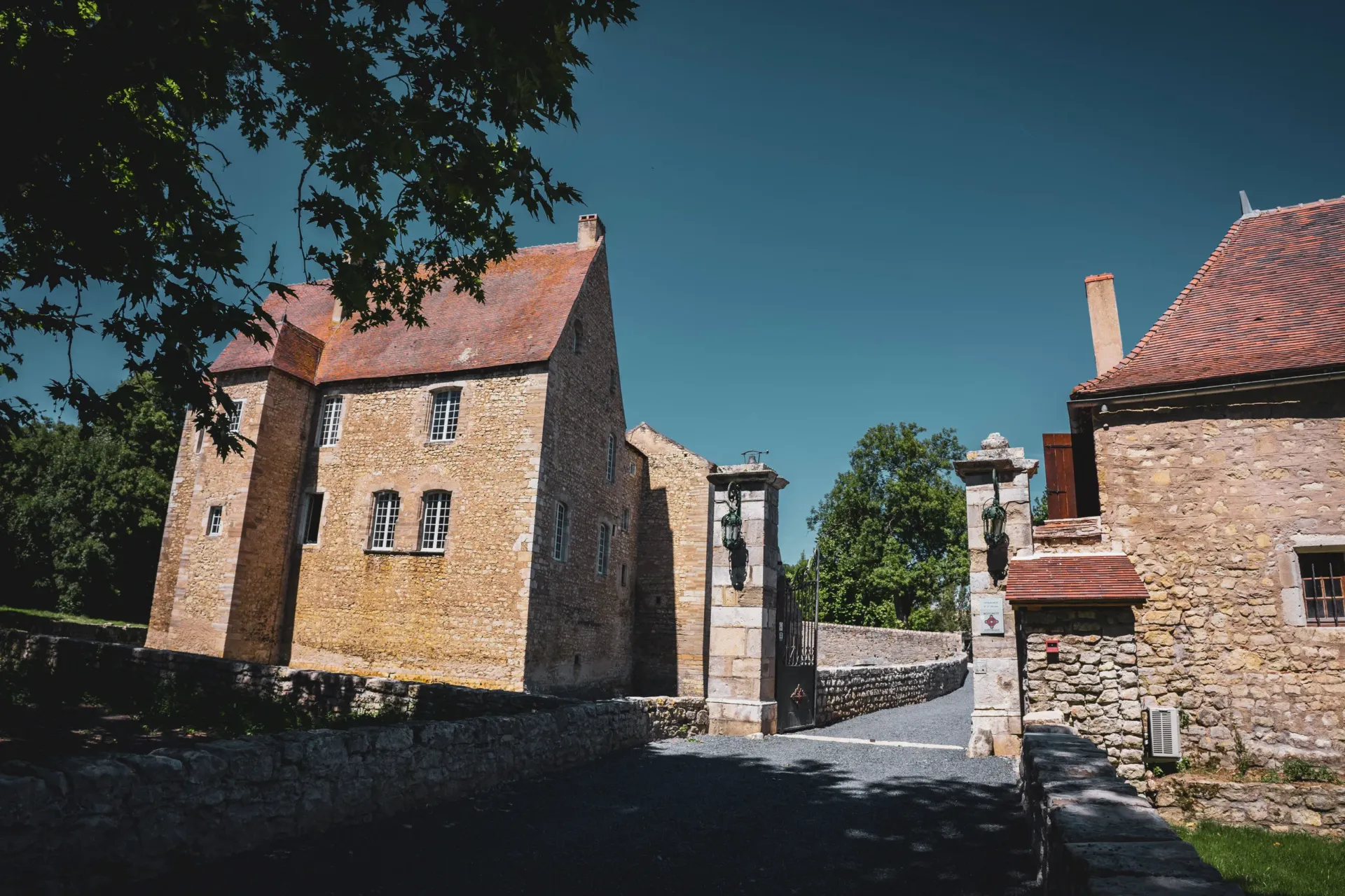 Entrée d'un château en pierre sous ciel bleu.
