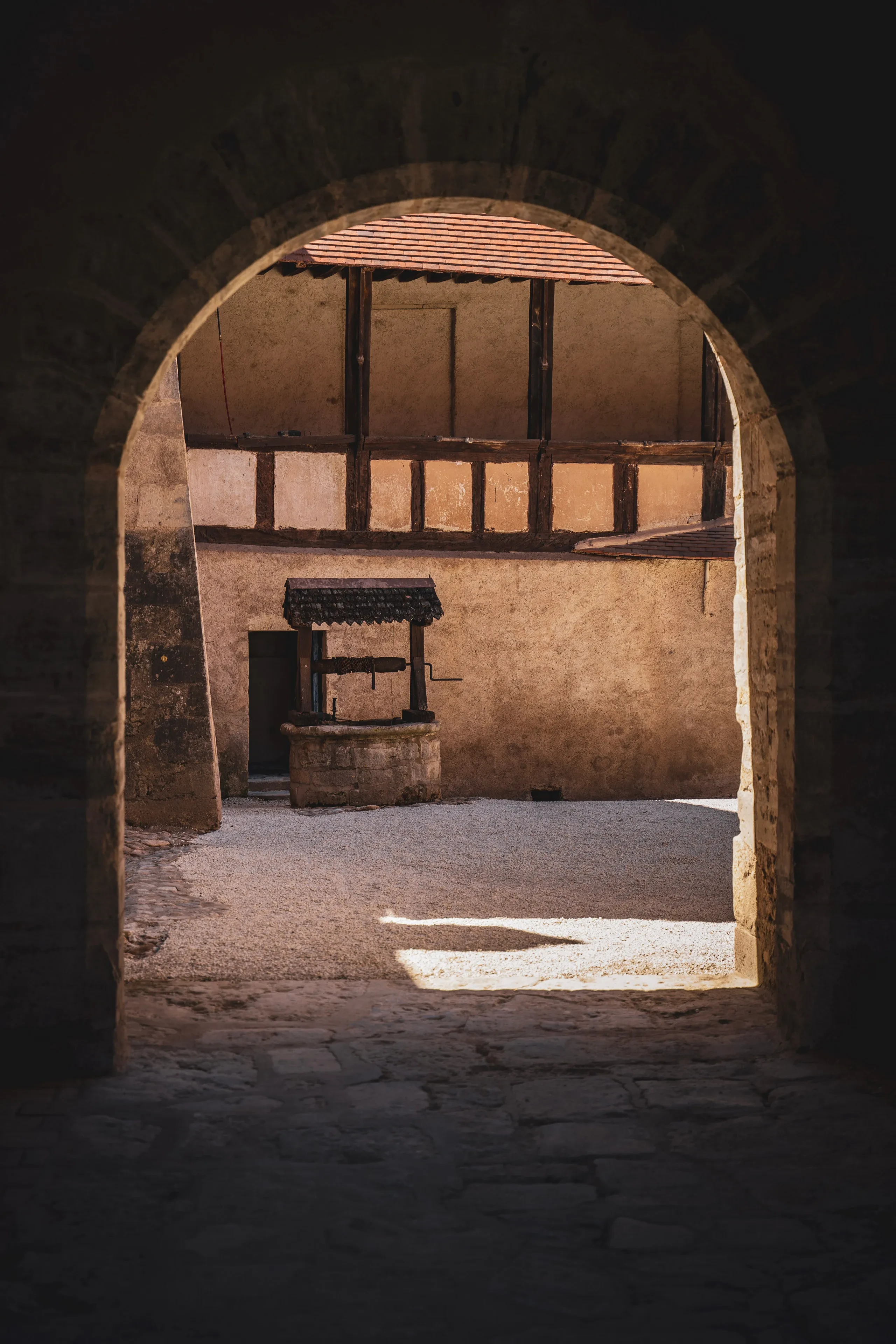 Cour intérieure avec puits et bâtiments anciens.