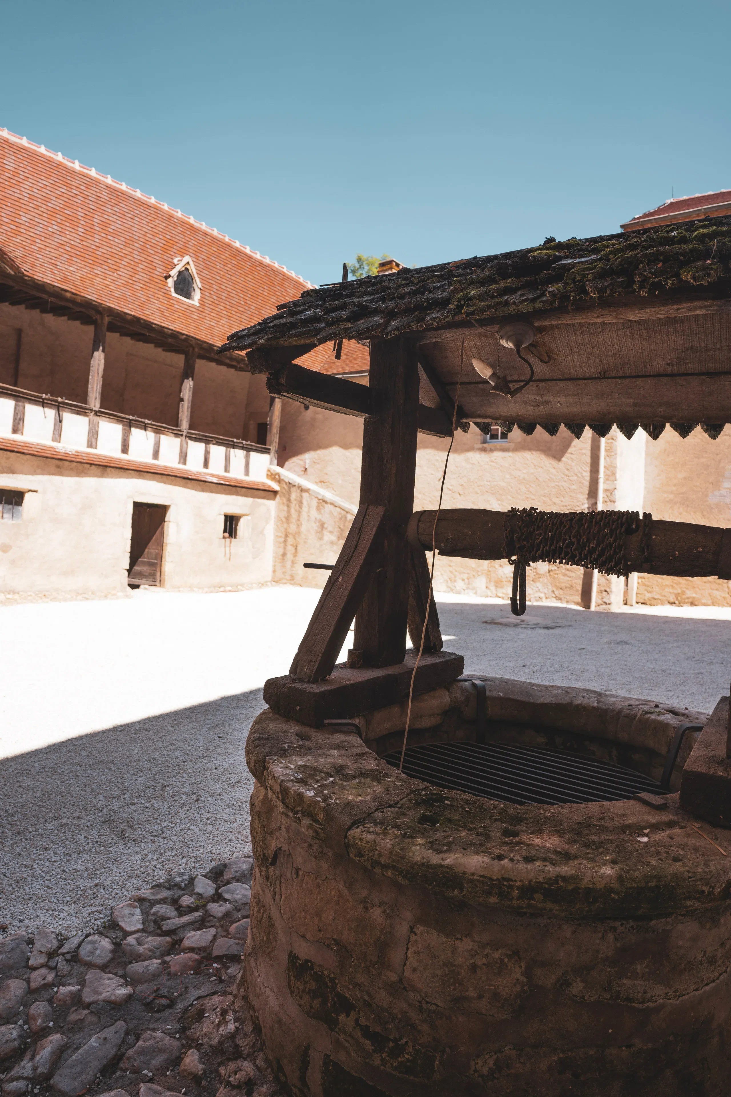 Puits en pierre dans cour de château.