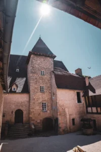 Château médiéval en pierre sous un ciel ensoleillé.