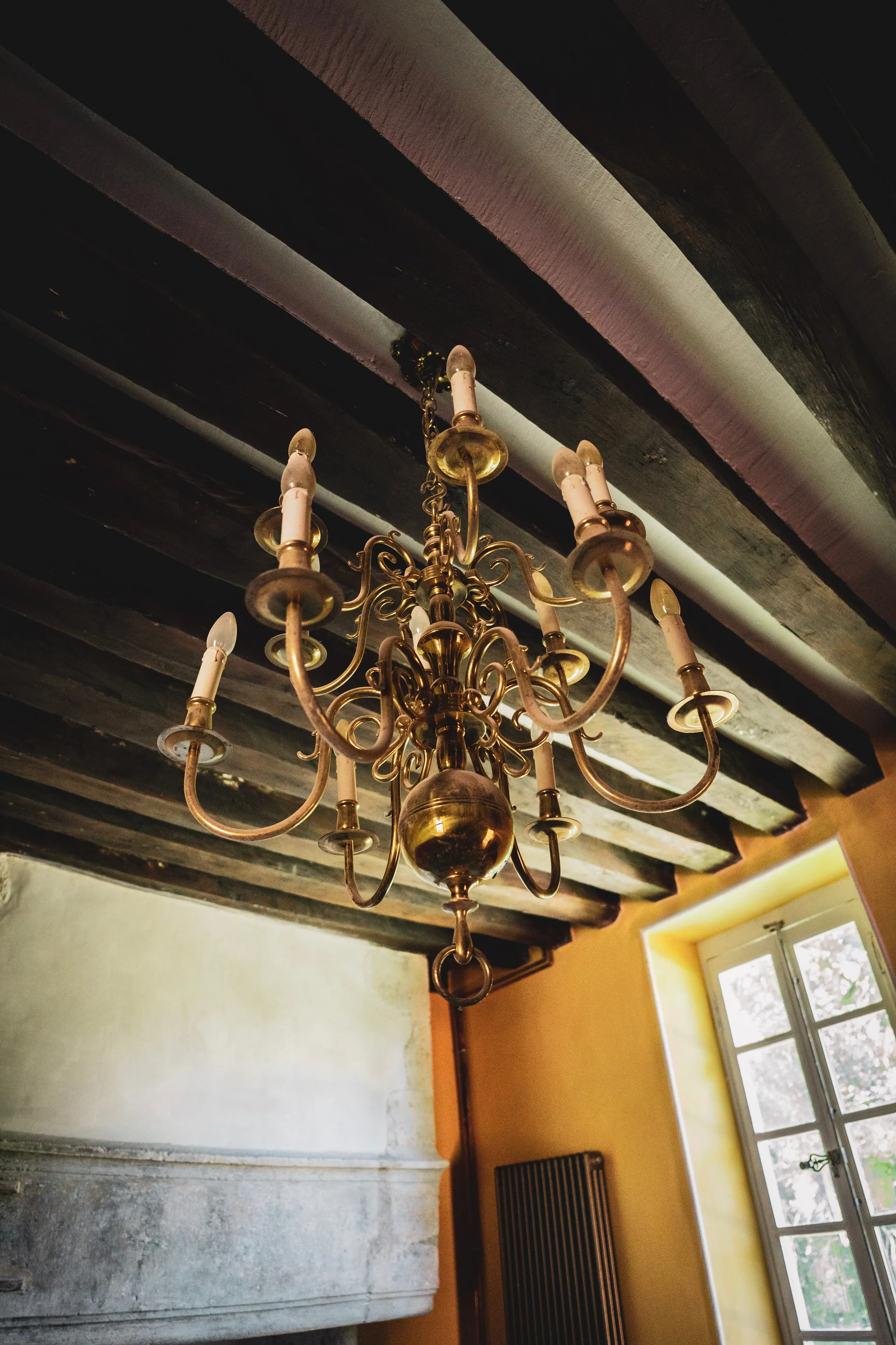 Lustre doré suspendu au plafond en bois.