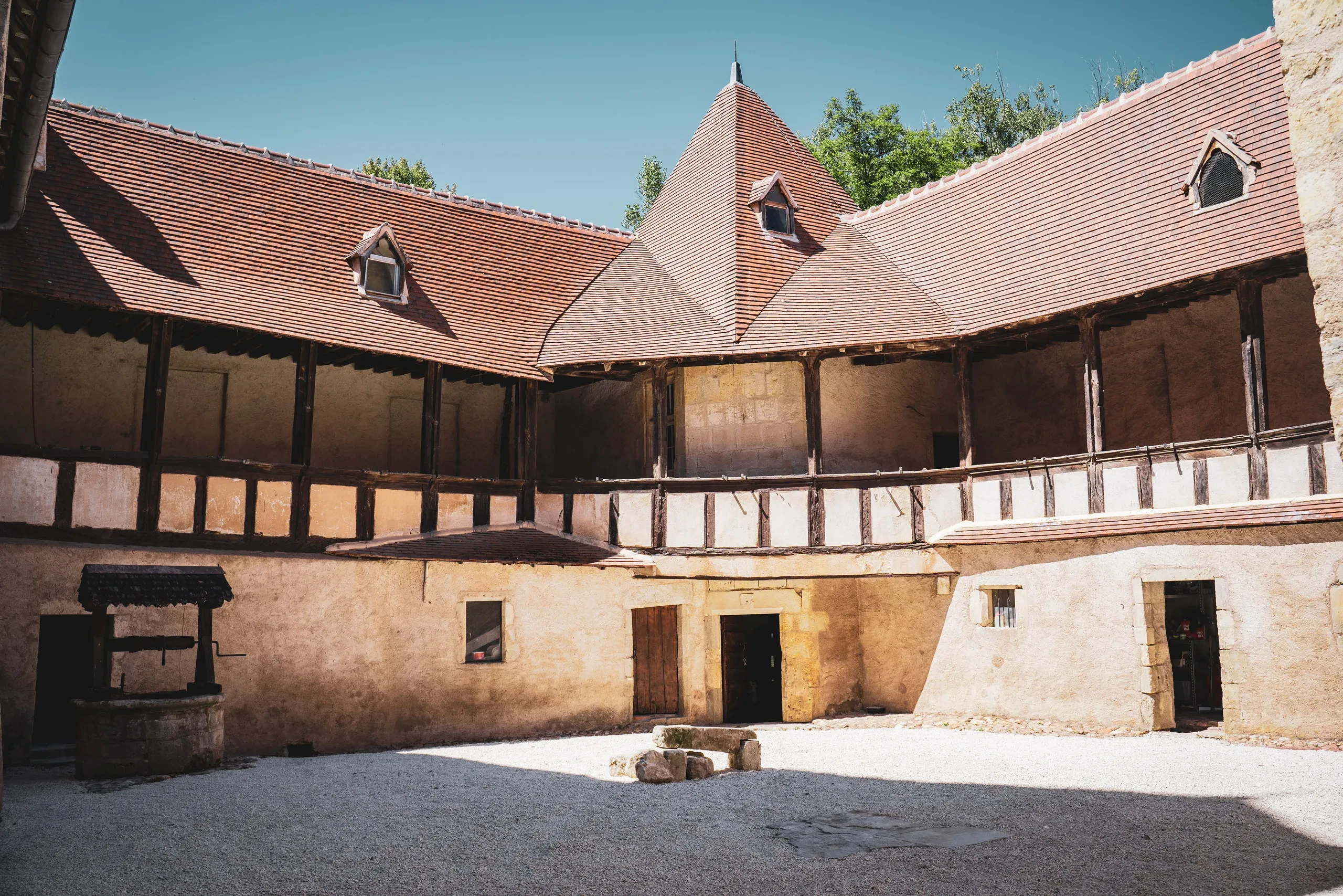 Cour intérieure historique avec puits et colombages.