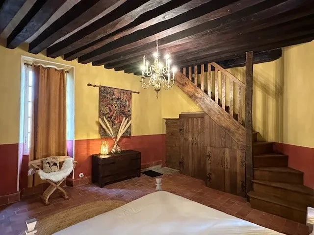 Chambre rustique avec plafond à poutres apparentes.