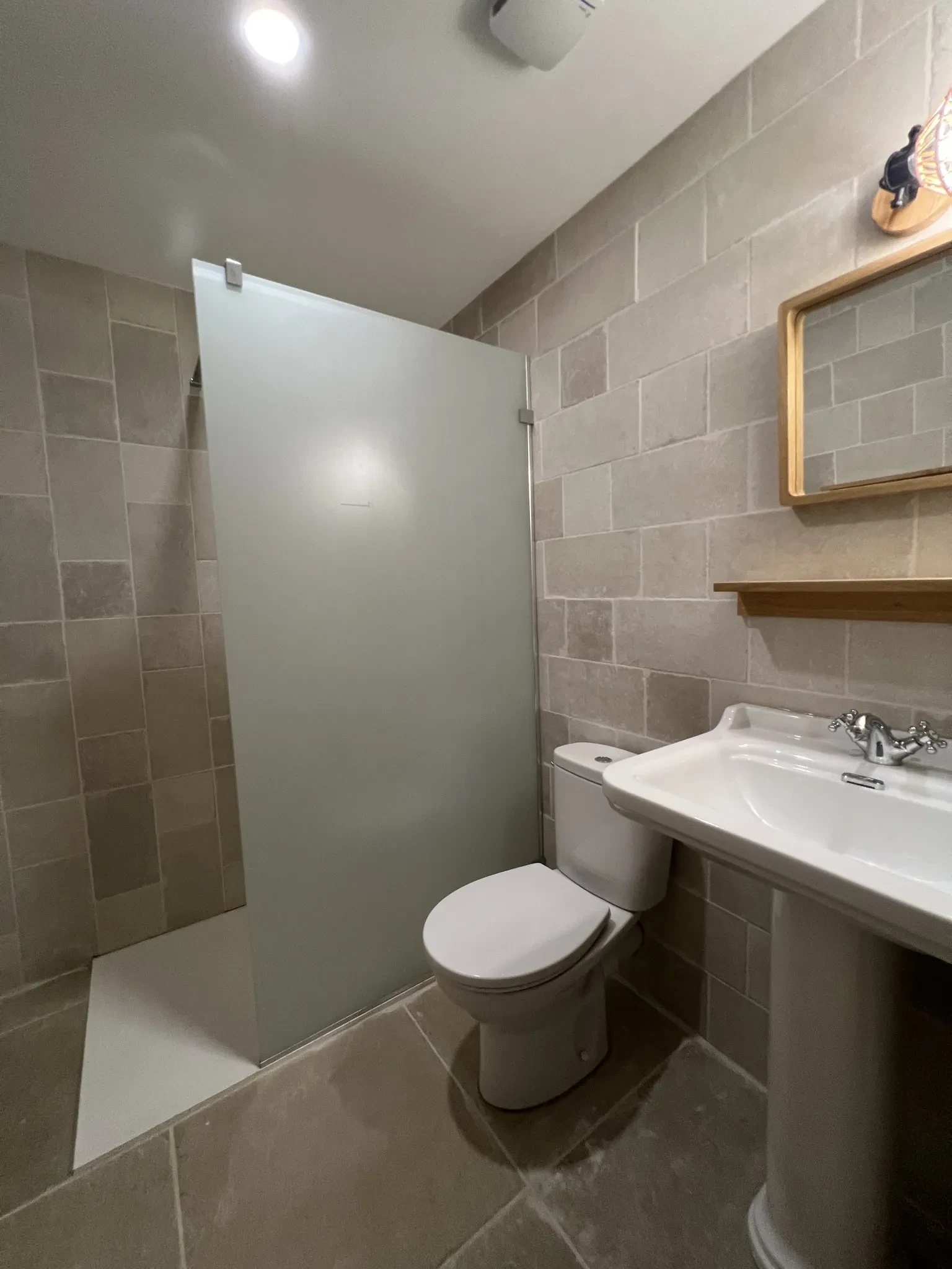Salle de bain moderne avec douche et lavabo.