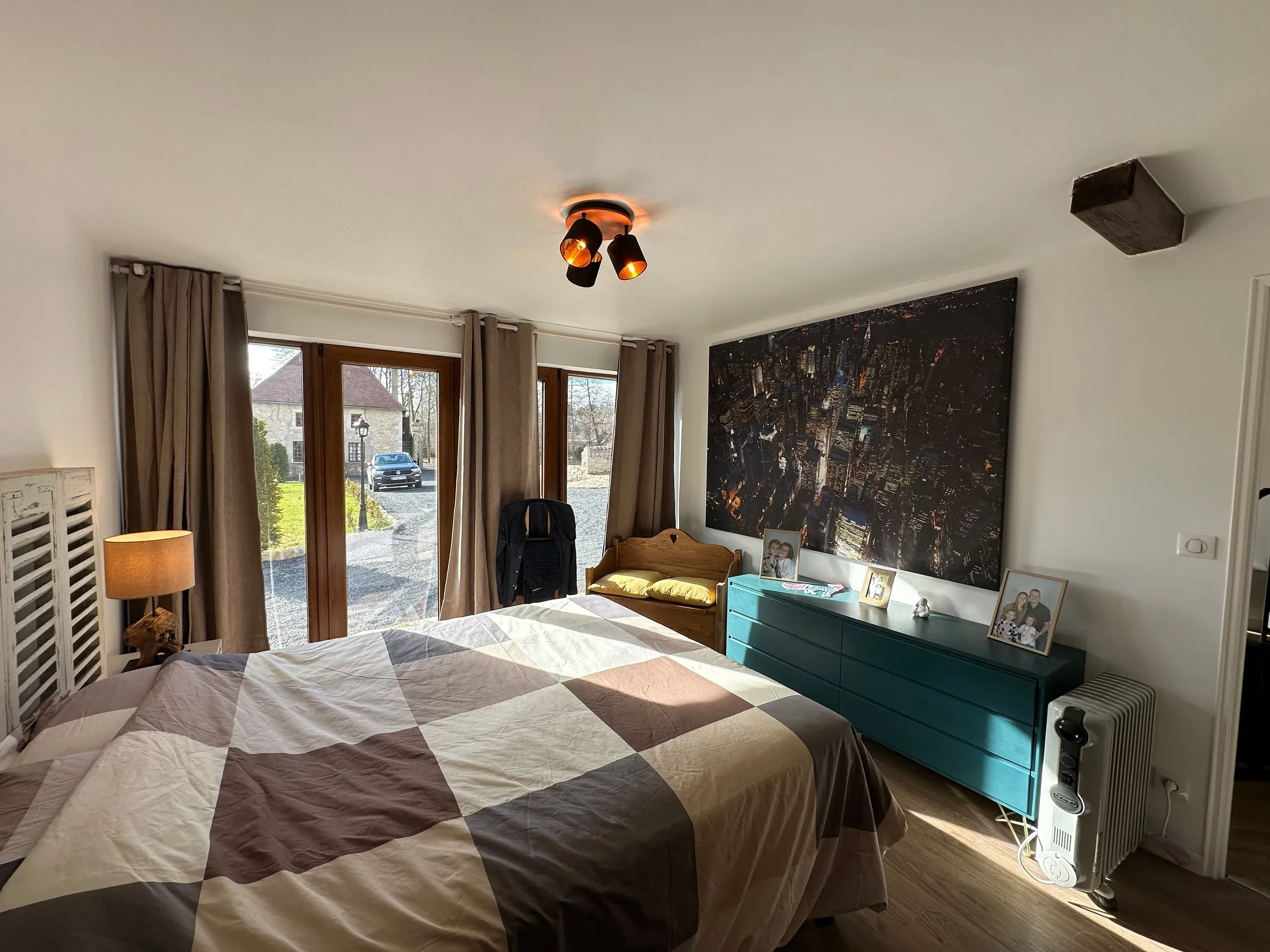 Chambre lumineuse avec vue sur jardin extérieur.