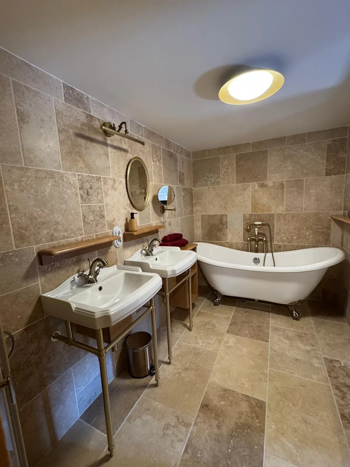 Salle de bain avec baignoire et deux lavabos.
