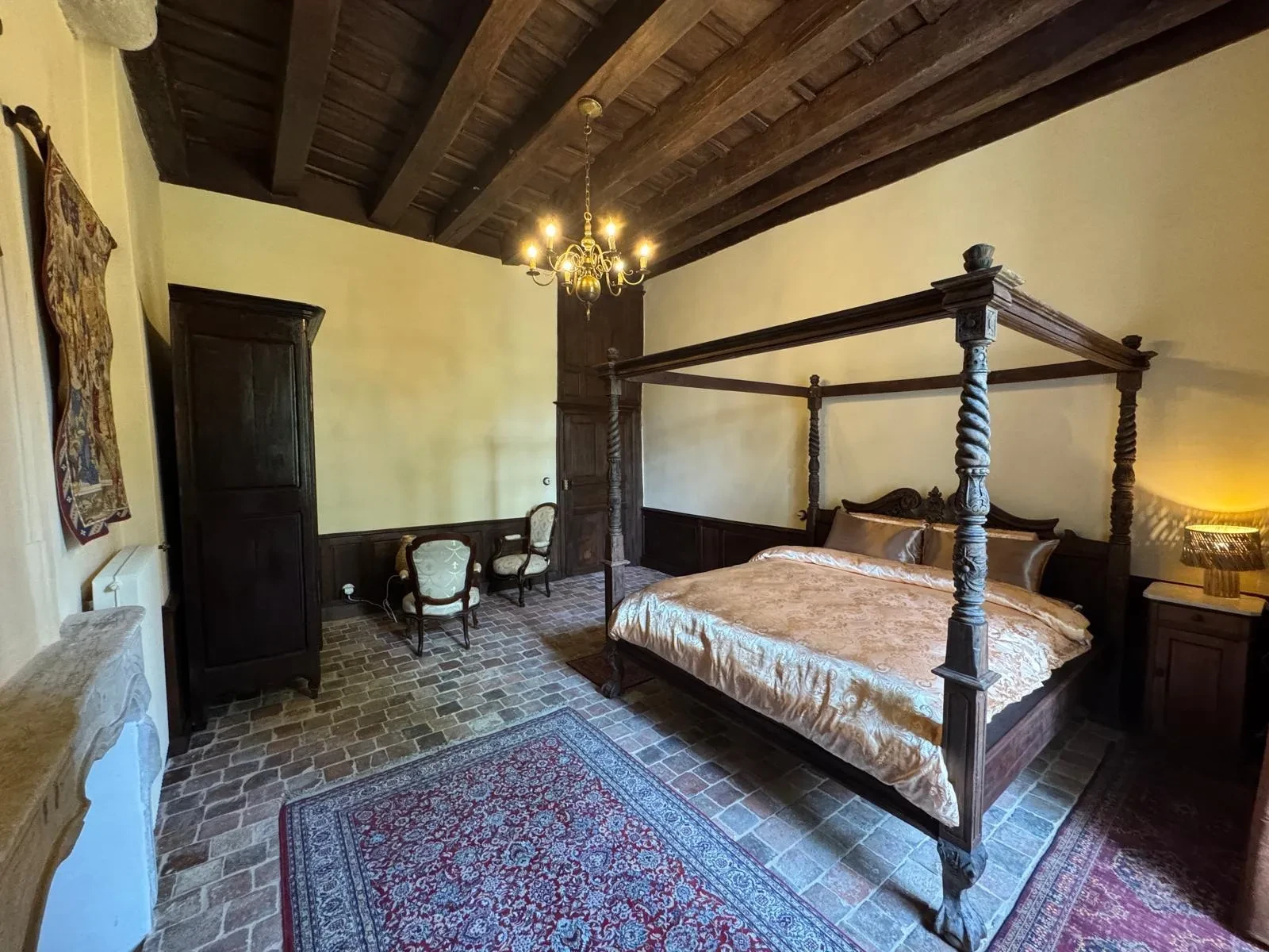 Chambre rustique avec lit à baldaquin en bois.