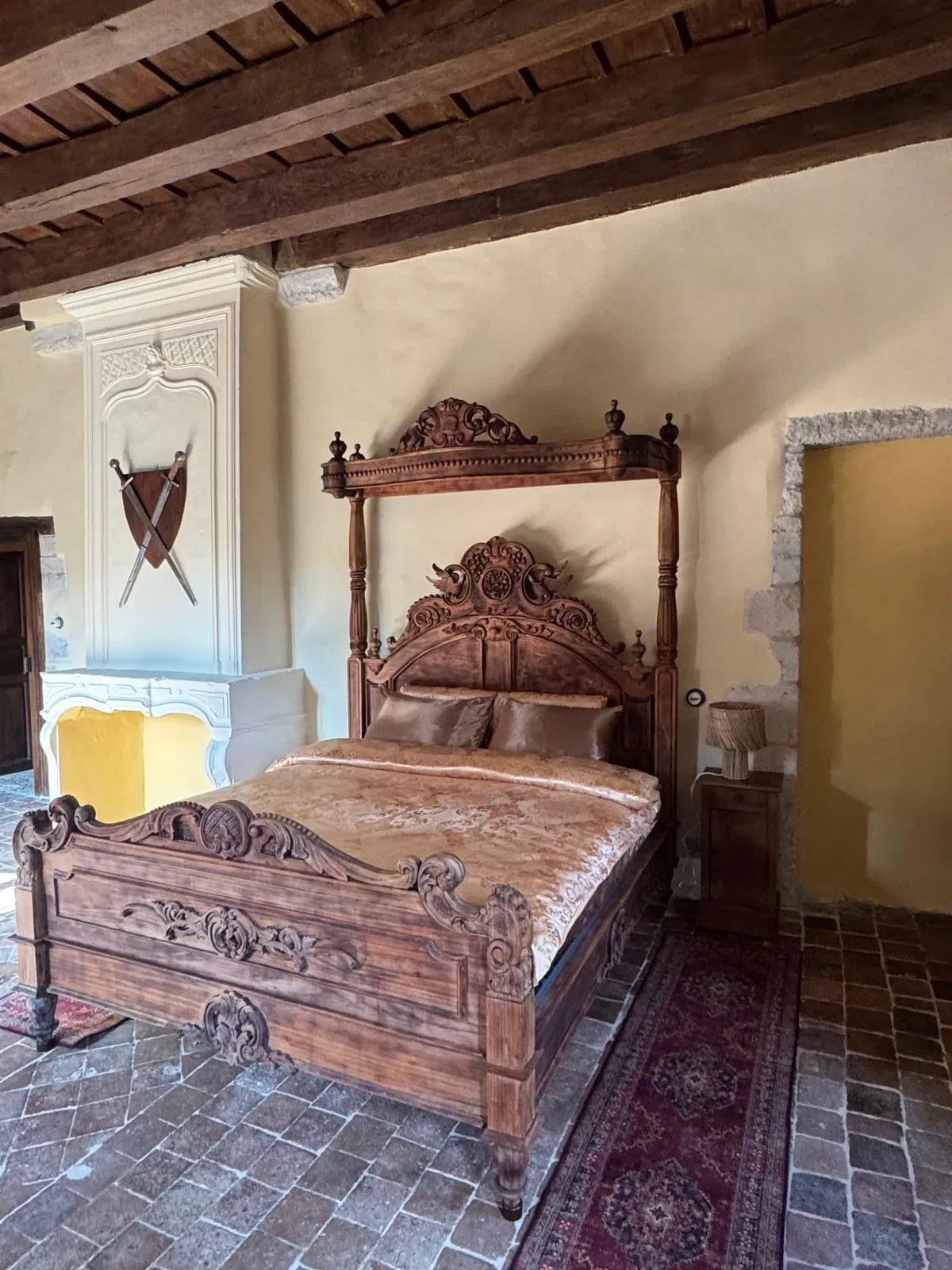 Chambre avec lit à baldaquin sculpté.