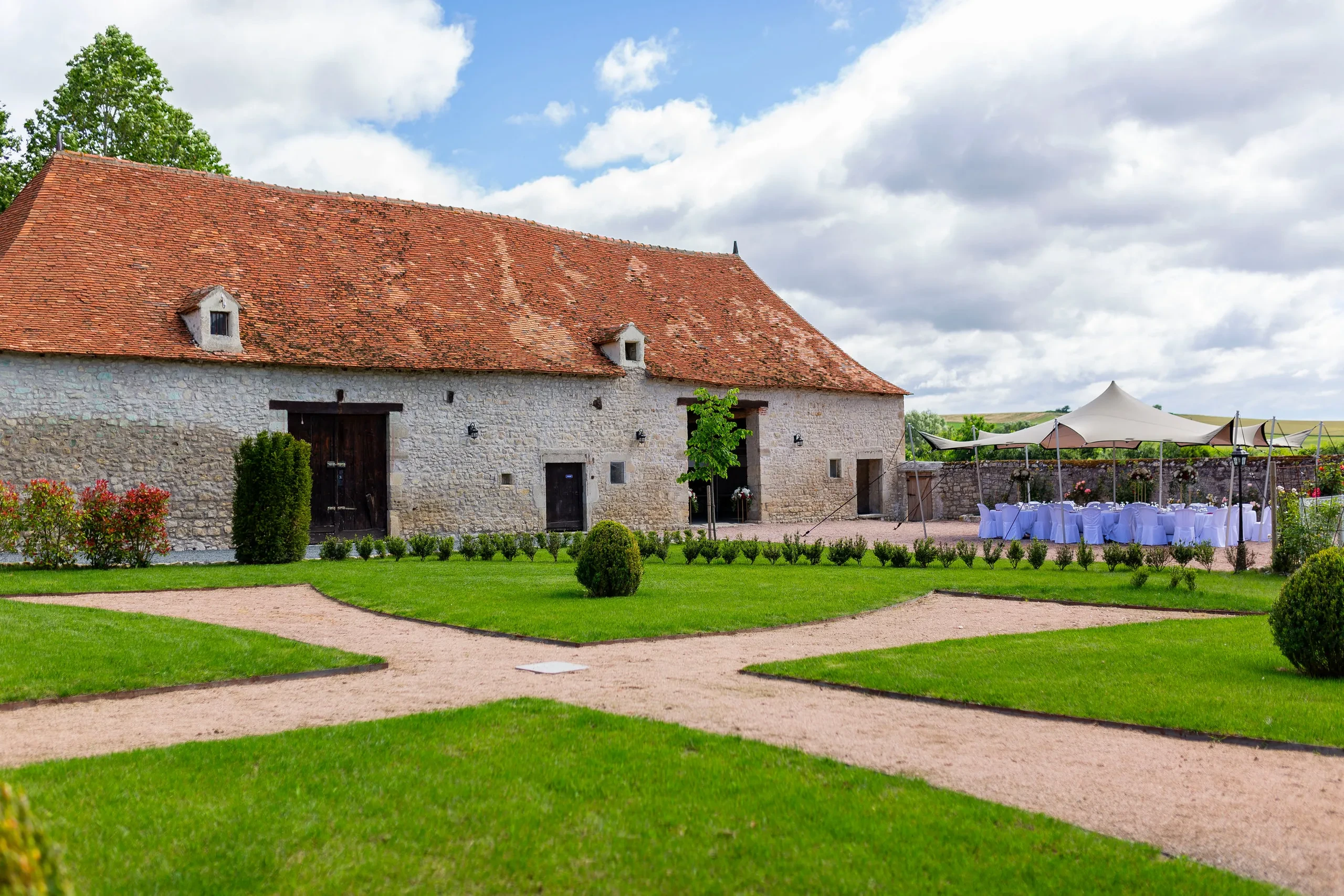 Grange ancienne avec jardin aménagé devant.
